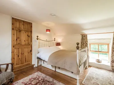 a bedroom with a white crib and a window at Hillgate House in Bromlow
