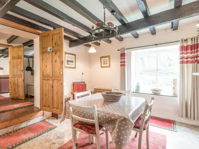 a dining room with a table and chairs and a window at Hillgate House in Bromlow