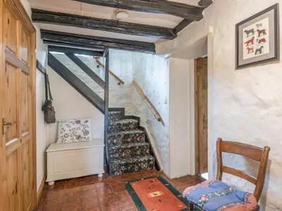 a staircase in a room with a chair and a table at Hillgate House in Bromlow