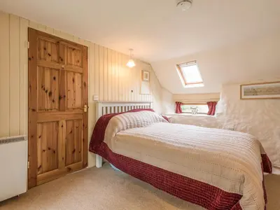a bedroom with a bed and a wooden door at Hillgate House in Bromlow