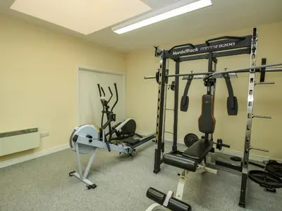 a gym with two treadmills and weights at The Wain House in Acton Scott