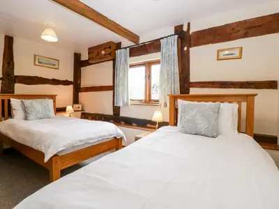 a bedroom with two beds and a window at Tippets View in Pembridge