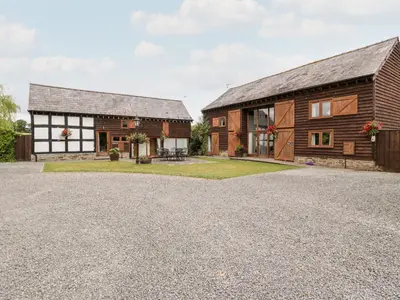 a barn style house with a gravel driveway at Tippets View in Pembridge