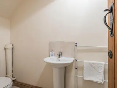 a bathroom with a sink and a toilet and a shower at Glebe Barn in Caynham