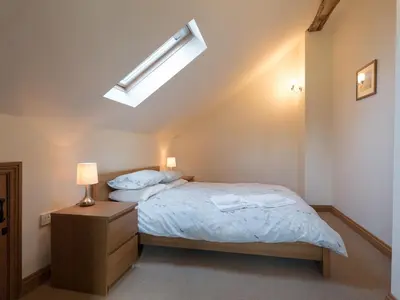 a small bedroom with a bed and a lamp at Glebe Barn in Caynham