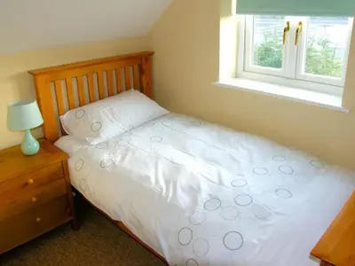 a bedroom with a white bed and a window at Manor Cottage in Ludlow