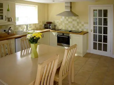 a kitchen with a table with a vase of flowers on it at Manor Cottage in Ludlow