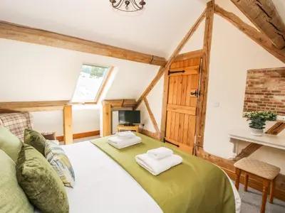 a bedroom with a bed with two towels on it at The Olde Cowshed in Acton Scott