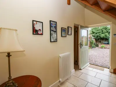 a room with a lamp and pictures on the wall at Old Coach House in Shrawardine