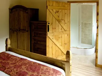 a bedroom with a large wooden door and a bed at Happy Union Stables in Abbey-Cwmhir