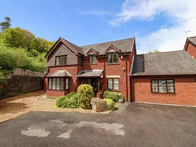 a brick house with a driveway in front of it at 1 The Beeches in Llangollen