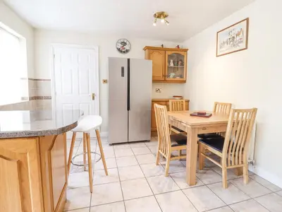 a kitchen with a table and a refrigerator at 1 The Beeches in Llangollen