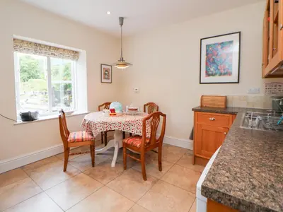 a kitchen with a table with chairs and a window at Bryn Howell Stables in Trevor