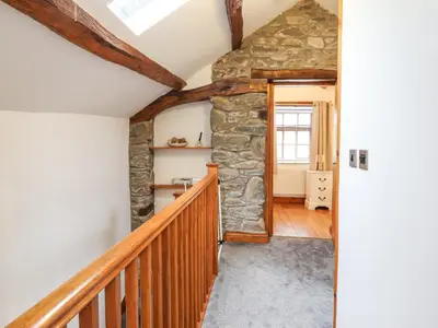a room with a stone wall and a stairway at Isallt in Llanbedr