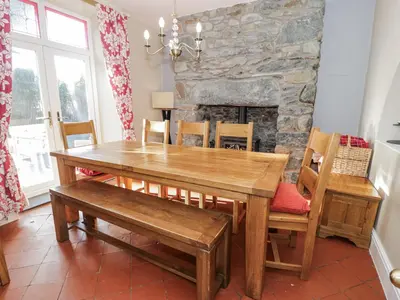 a dining room with a wooden table and chairs at Tyddyn Goronwy in Dyffryn