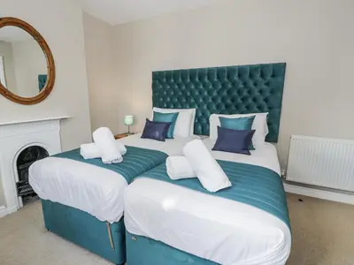 a bedroom with two beds with blue and white pillows at Tyddyn Goronwy in Dyffryn