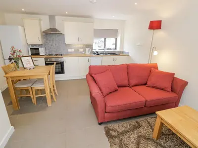 a living room with a red couch and a table at Kite's Nest in Eaton