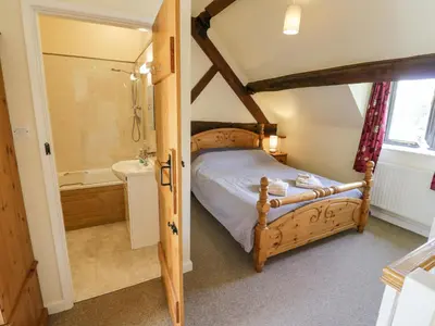 a bedroom with a bed and a tub and a sink at Kite's Nest in Eaton