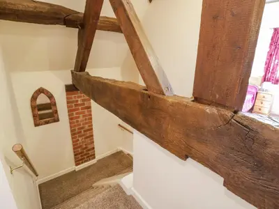 a wooden beam on the wall of a staircase with a window at Betty's Barn in Eaton