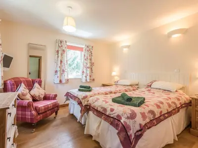 a bedroom with a bed and a chair and a window at The Schoolhouse Brewhouse in Bishops Castle