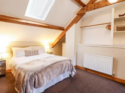 a bedroom with a bed and a vaulted ceiling at Cwm Yr Afon Cottage in Harlech