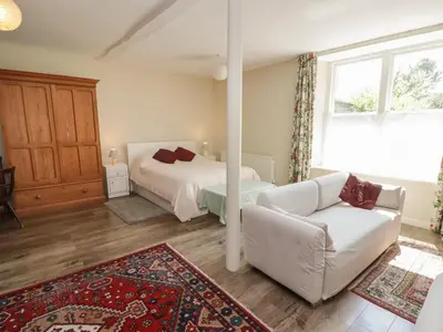 a living room with a bed and a couch at The School Room in Kington
