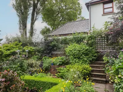 a garden in front of a white house at The School Room in Kington