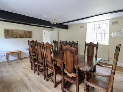 a dining room with a wooden table and chairs at Bryn Cemlyn in Llanfachreth