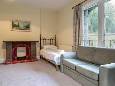a living room with a couch and a fireplace at Bryn Cemlyn in Llanfachreth