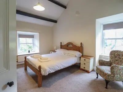 a bedroom with a bed and a chair at Bryn Cemlyn in Llanfachreth