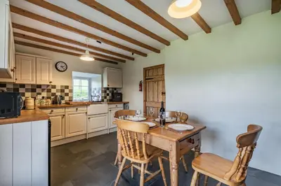 a kitchen with a wooden table and chairs at Ty Capel Jeriwsalem in Trawsfynydd