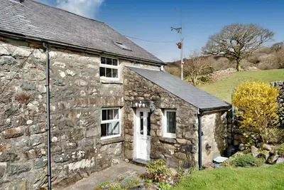 an old stone house with a white door at Ty Capel Jeriwsalem in Trawsfynydd