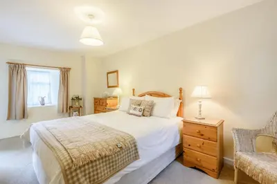 a bedroom with a large bed and a chair at Penty in Dolgellau