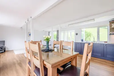 a kitchen and dining room with a wooden table and chairs at Penty in Dolgellau