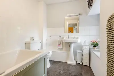 a white bathroom with a sink and a bath tub at Penty in Dolgellau
