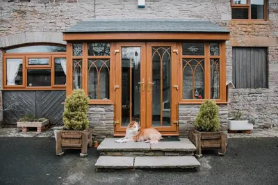 a dog sitting in front of a greenhouse at Stargazer's Loft in Clifford