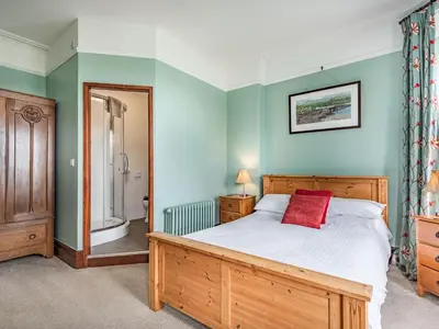 a bedroom with a large bed and a mirror at Pensarn Hall in Llanbedr