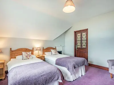 a bedroom with two beds and a window at Pensarn Hall in Llanbedr