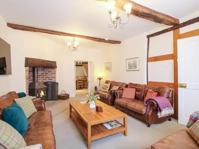 a living room with leather furniture and a fireplace at The Maltster's House in Ludlow