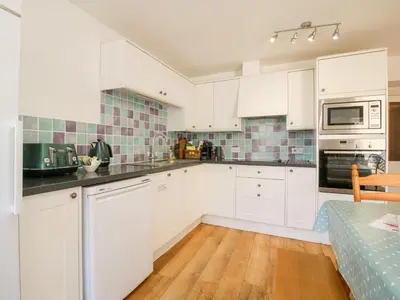 a white kitchen with white cabinets and a table at The Maltster's House in Ludlow
