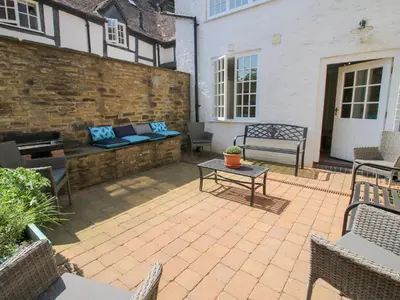 a patio with a bench and a table at The Maltster's House in Ludlow