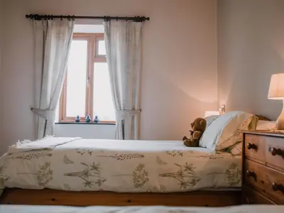 a bedroom with a bed with a teddy bear on it at Stargazer's Field House in Clifford