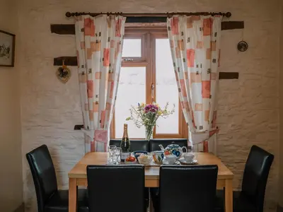 a dining room table with chairs and a window at Stargazer's Field House in Clifford