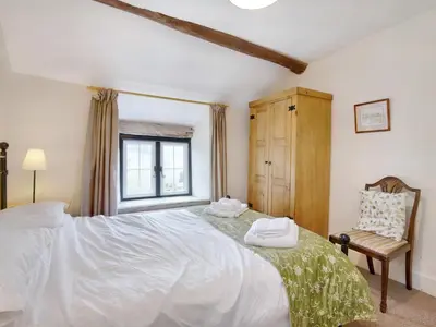 a bedroom with a large white bed and a chair at The Birches in Craswall