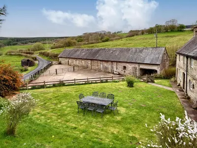 a picnic table in a field next to a barn at The Birches in Craswall