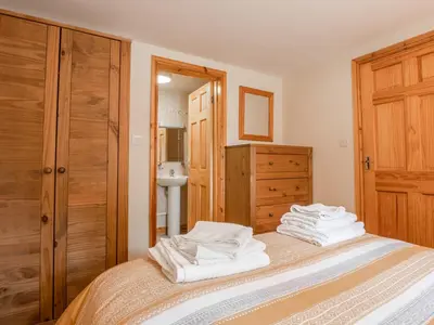 a bedroom with a bed with white towels on it at Hendre Cottage in Trawsfynydd