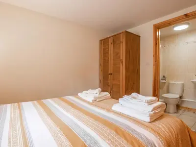a bedroom with a bed with towels on it at Hendre Cottage in Trawsfynydd