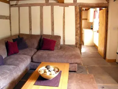 a living room with a couch and a bowl on a table at Point Cottage in Blakemere