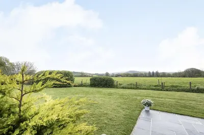 a garden with a grassy yard and a field at 2 Siluria Cottage in New Radnor