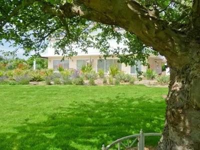 a house in a yard with a green lawn at Herons in Byford
